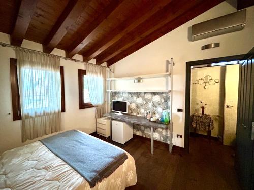 1 dormitorio con 1 cama y escritorio con ordenador en Damabianca, en Portogruaro