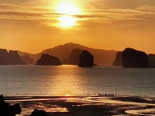 a group of people on the beach at sunset at Connexion in Ko Yao Noi