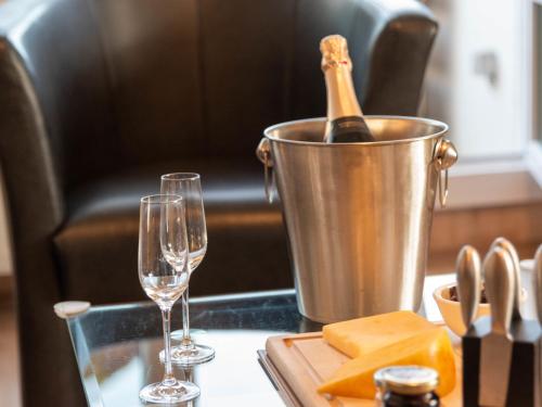 eine Flasche Champagner in einem Eimer auf einem Tisch mit Brille in der Unterkunft Apartment Blinkfeuer by Interhome in Norddeich