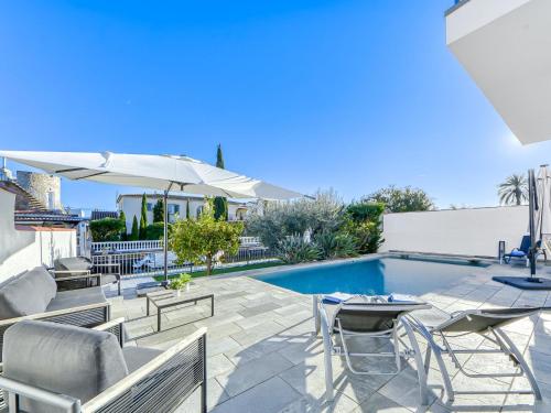 a patio with a pool and chairs and an umbrella at Holiday Home Norfeu by Interhome in Empuriabrava