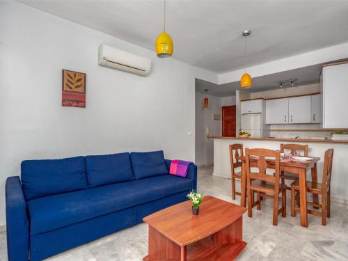 a living room with a blue couch and a table at Apartment Torrealba by Interhome in Fuengirola