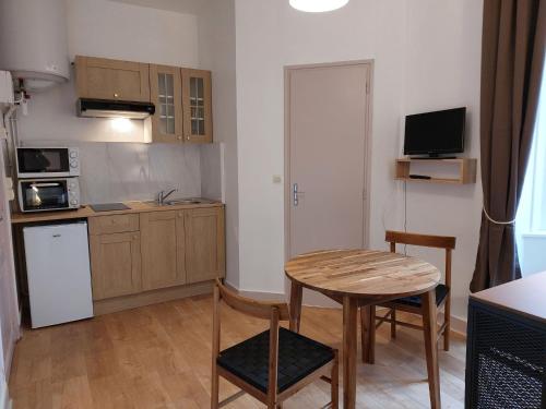拉理查戴斯的住宿－Apartment Le Petit Robinson-7 by Interhome，小厨房配有桌子和小桌子及椅子