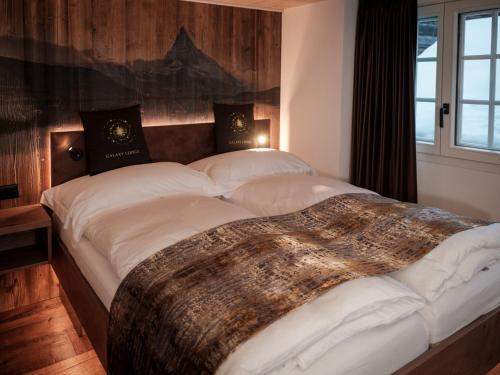 ein großes Bett in einem Zimmer mit Fenster in der Unterkunft Apartment Kirchplatz by Interhome in Zermatt
