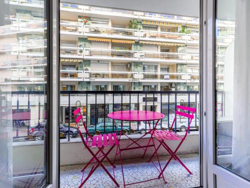 une table et des chaises roses sur un balcon avec un bâtiment dans l'établissement Apartment Le Mozart by Interhome, à Nice