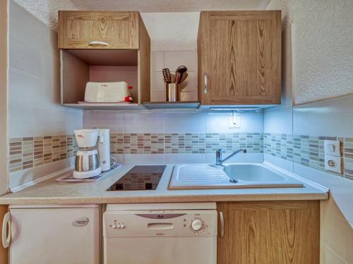 une cuisine avec des armoires en bois et un évier dans l'établissement Apartment Les Gentianes 110 by Interhome, aux Menuires