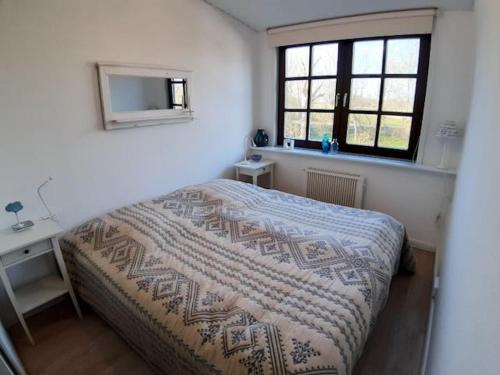 - une chambre avec un lit, un bureau et une fenêtre dans l'établissement Nordseewölckchen 2, à Katingsiel
