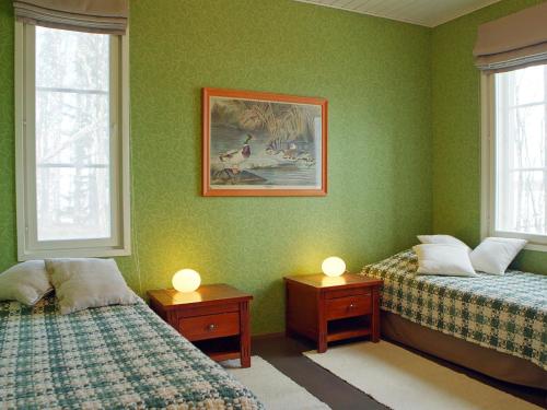 2 Betten in einem Zimmer mit grünen Wänden und Fenstern in der Unterkunft Holiday Home Villa raita by Interhome in Oravisalo