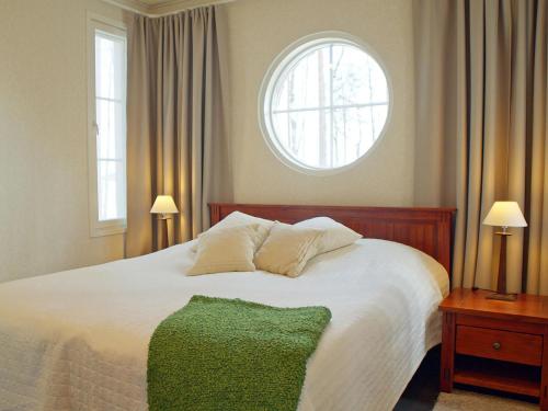 Schlafzimmer mit einem großen weißen Bett und einem Fenster in der Unterkunft Holiday Home Villa raita by Interhome in Oravisalo