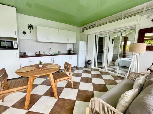 uma sala de estar com uma mesa e uma cozinha em Gîtes KUMQUAT em Petit-Bourg