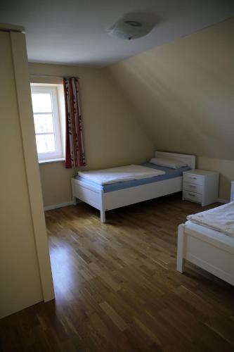 a small room with two beds and a window at Ademi in Süderhöft