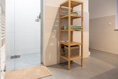 baño con ducha y estante con toallas en Zentrale und moderne Neubauwohnung in Oranienburg, en Oranienburg