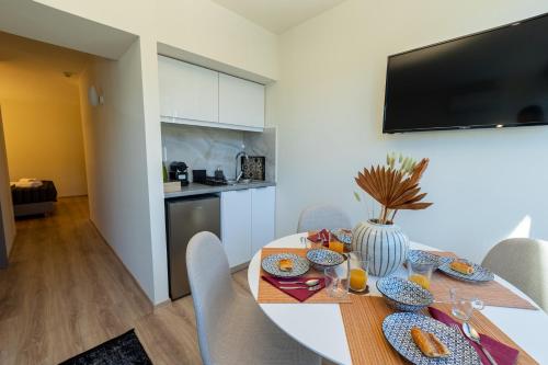 a dining room with a white table and chairs at Athens Airport Living spaces in Spáta