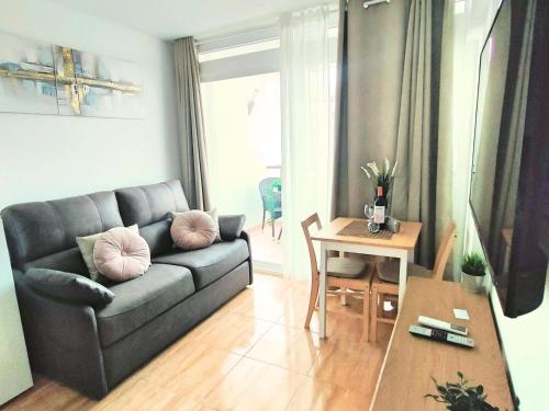 un soggiorno con un divano e un tavolo di Magic Conch Holiday Home a Playa del Ingles