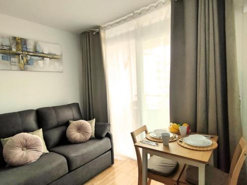 un soggiorno con un divano e un tavolo di Magic Conch Holiday Home a Playa del Ingles