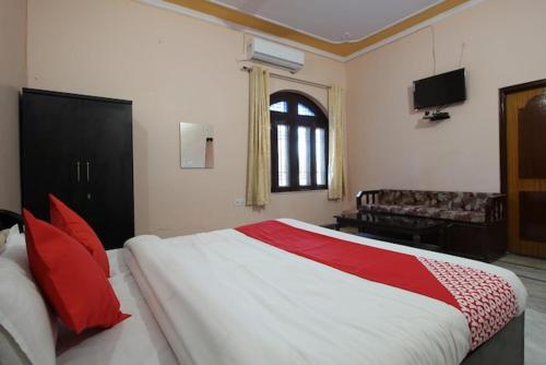 ein Schlafzimmer mit einem großen Bett mit roten Kissen in der Unterkunft Hotel Pink Haveli in Jaipur