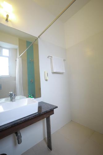 a bathroom with a sink and a mirror at Ixora Suites in Bengaluru