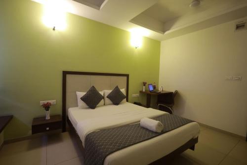 a hotel room with a bed and a night stand at Ixora Suites in Bengaluru