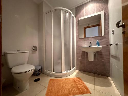uma casa de banho com um chuveiro, um WC e um lavatório. em Alicante Hills Luxury Beach Apartment em Alicante
