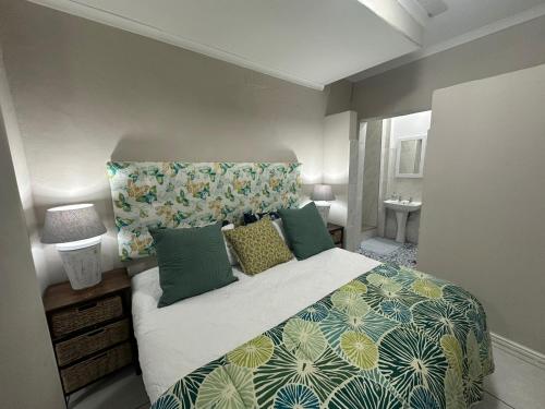 a bedroom with a large bed with green pillows at On the Beach in Durban