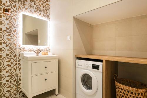 a bathroom with a washing machine and a sink at Le Laurencin Sens - La Mezzanine - Cœur de ville in Sens