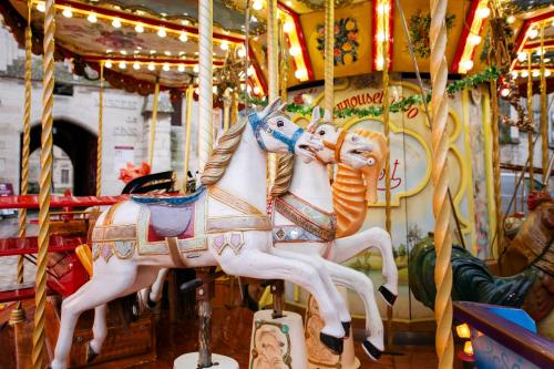 a carousel with two horses on a carousel at Le Laurencin Sens - La Mezzanine - Cœur de ville in Sens