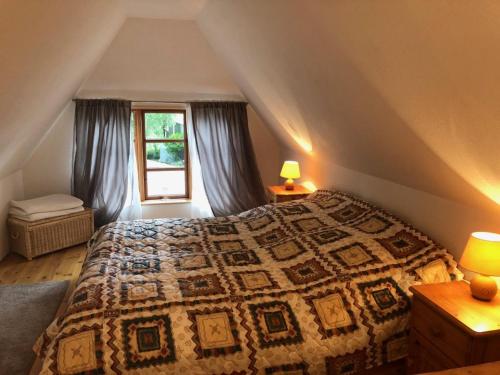 a bedroom with a bed and a window and two lamps at Landhaus Everschop in Tetenbüll