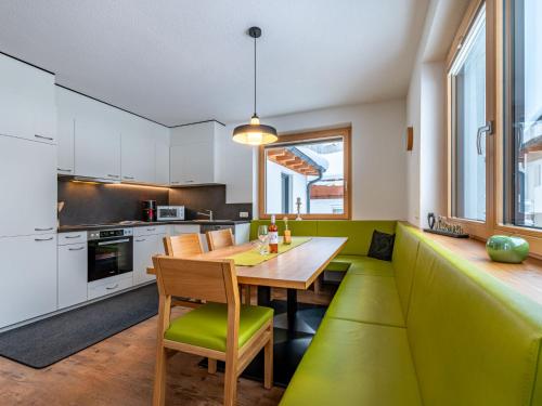 eine Küche mit einem Holztisch und grünen Akzenten in der Unterkunft Apartment Martina - KPL576 by Interhome in Kappl