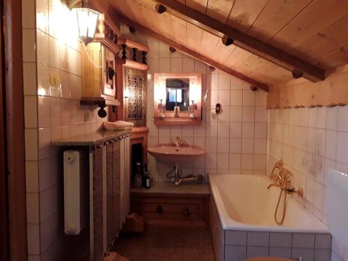 y baño con bañera y lavamanos. en Ferienhäuser zum Badeweiher, en Neuschönau