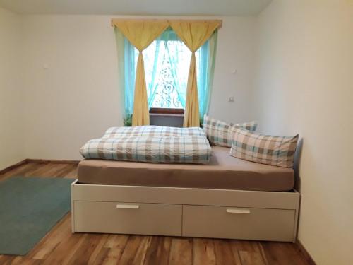 un lit dans une chambre avec une fenêtre dans l'établissement Ferienhäuser zum Badeweiher, à Neuschönau