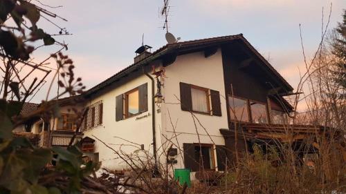 a white house with windows on the side of it at Ferienhäuser zum Badeweiher in Neuschönau