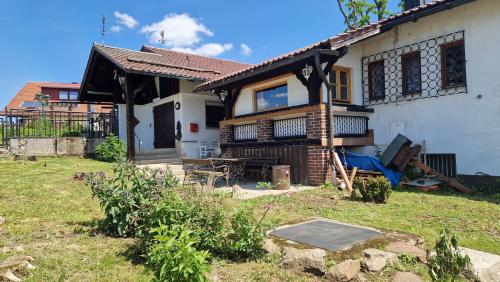 a white house with a blue chair in the yard at Ferienhäuser zum Badeweiher in Neuschönau