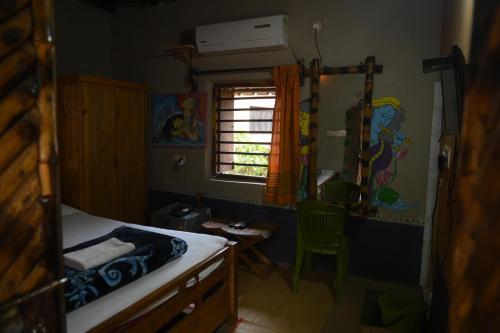 サンティ・ニケタンにあるRam Shyam Village Resortの小さなベッドルーム(ベッド1台、窓付)
