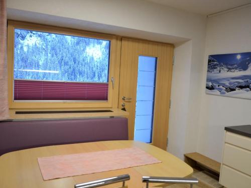 Zimmer mit einem Tisch und einem Fenster in der Unterkunft Apartment Hedwig Jäger - KPL420 by Interhome in Kappl