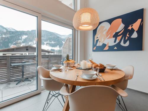 a dining room with a table and chairs and a large window at Apartment Das Georgen- Kitzsteinhorn by Interhome in Fürstau