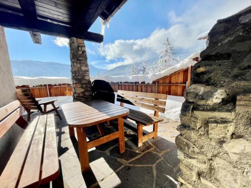 a table and benches on a patio with snow at Holiday Home Solea by Interhome in Imst