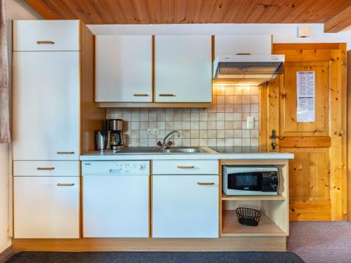 kuchnia z białymi szafkami i kuchenką mikrofalową w obiekcie Apartment Sailer - KPL321 by Interhome w mieście Kappl