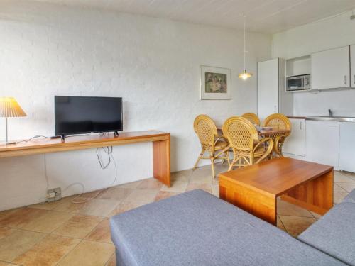 sala de estar con mesa, sillas y TV en Apartment Gunnlaug - 500m from the sea in Western Jutland by Interhome, en Lakolk