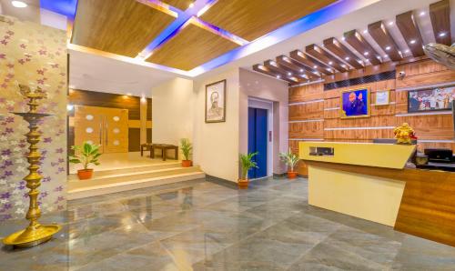 an office lobby with a reception desk and a staircase at Treebo Golden Swan Pammal in Chennai
