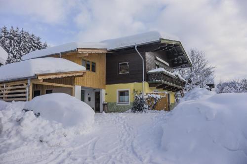 a house covered in snow with snow piled up at Latina II in Westendorf