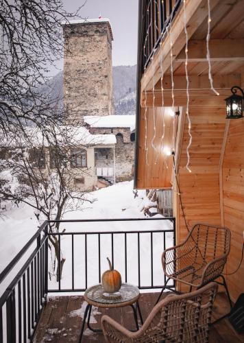 a table and chairs on a balcony with an apple on it at M&L in Mestia