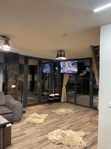 a living room with a couch and a tv at Valea Mosului - Cozy A Frame in Petroşani
