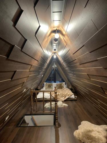 a room with a bed in a wooden ceiling at Valea Mosului - Cozy A Frame in Petroşani