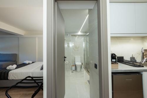 スパタにあるAthens Airport Living spacesのベッド付きの部屋、ガラスドア付きのキッチン