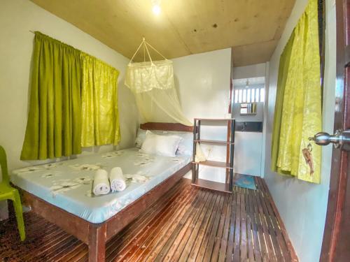 - une chambre avec un lit doté de rideaux verts et d'une échelle dans l'établissement Eashantis Place, à San Vicente