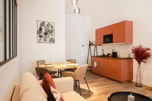 a living room with a couch and a table at Le Laurencin Sens - Le Peachy - Cœur de ville in Sens