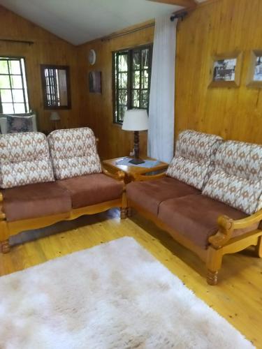 a living room with two couches and a table at Crocodile Nest B&B in Nelspruit