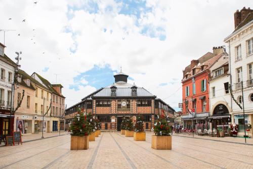 a city street with a building with christmas trees at Le Laurencin Sens - Le Peachy - Cœur de ville in Sens
