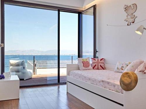 a bedroom with a bed with a view of the ocean at Villa Bellavista in Cala Blava