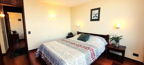 ein Schlafzimmer mit einem Bett und einem Tisch mit einem Kissen in der Unterkunft Depto frente a la playa Av San Martin in Viña del Mar