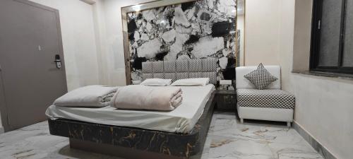 a bedroom with a bed and a chair and a mirror at DIAMOND GUEST HOUSE in Kolkata